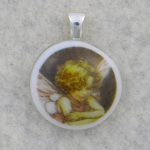 Small fused glass pendant with a fairy decal fused on to a white base. Small fused glass pendant with a fairy decal fused on to a white base.